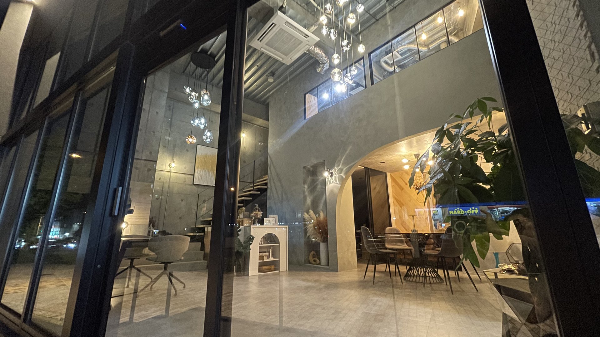 照明が灯った夜のIROHA HOME店舗（吹抜けの店内）